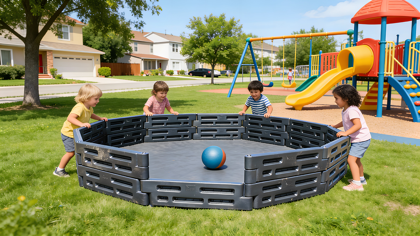 Children playing Gaga Ball inside a 15-foot black plastic Gaga Ball Pit at a sunny park with a playground in the background.